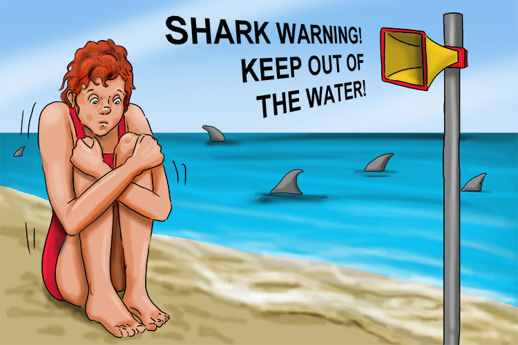 She started to shiver as she came out of the sea after a shark warning.